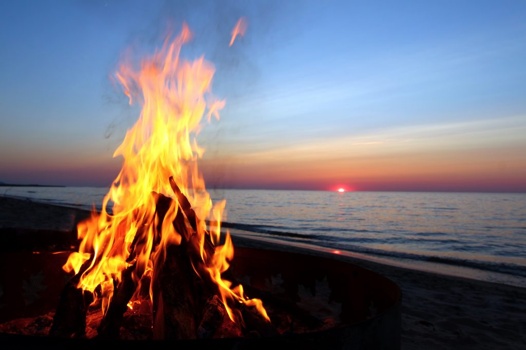 Lagerfeuer am Strand bei Sonnenuntergang